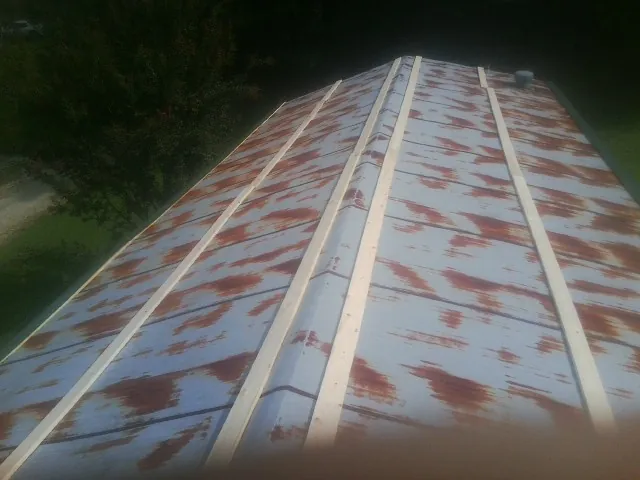 Rusted metal roof panels with new wood purlins before replacement — Storm Damage Roof Repair in Finger by Roofing Brothers