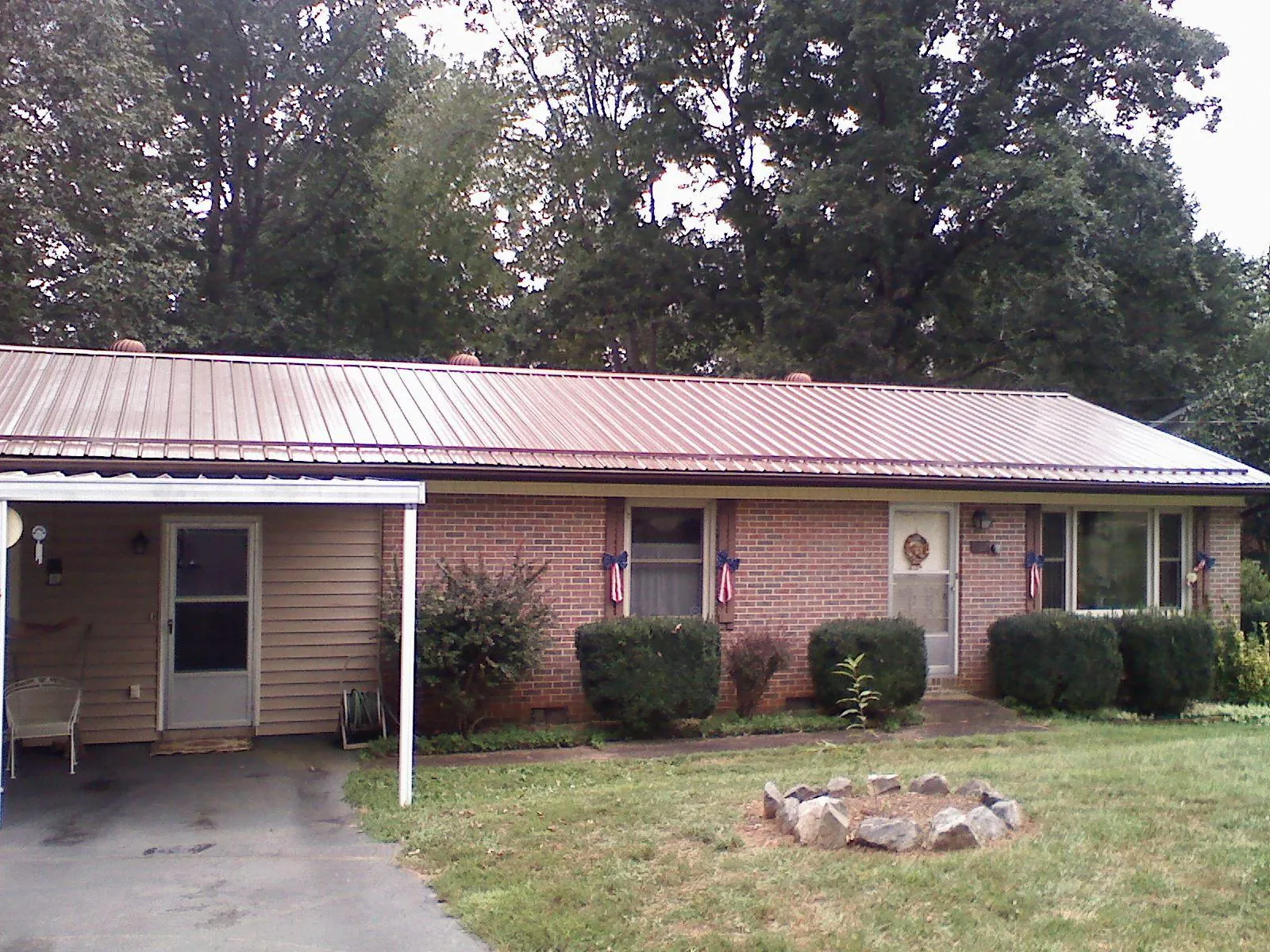 Bronze metal roof and carport on a brick ranch home — Roof Repair work by our crew in Finger
